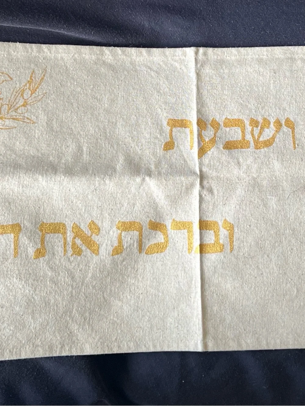 Gold and cream Shabbat tablecloth with gold Hebrew text and illustrations